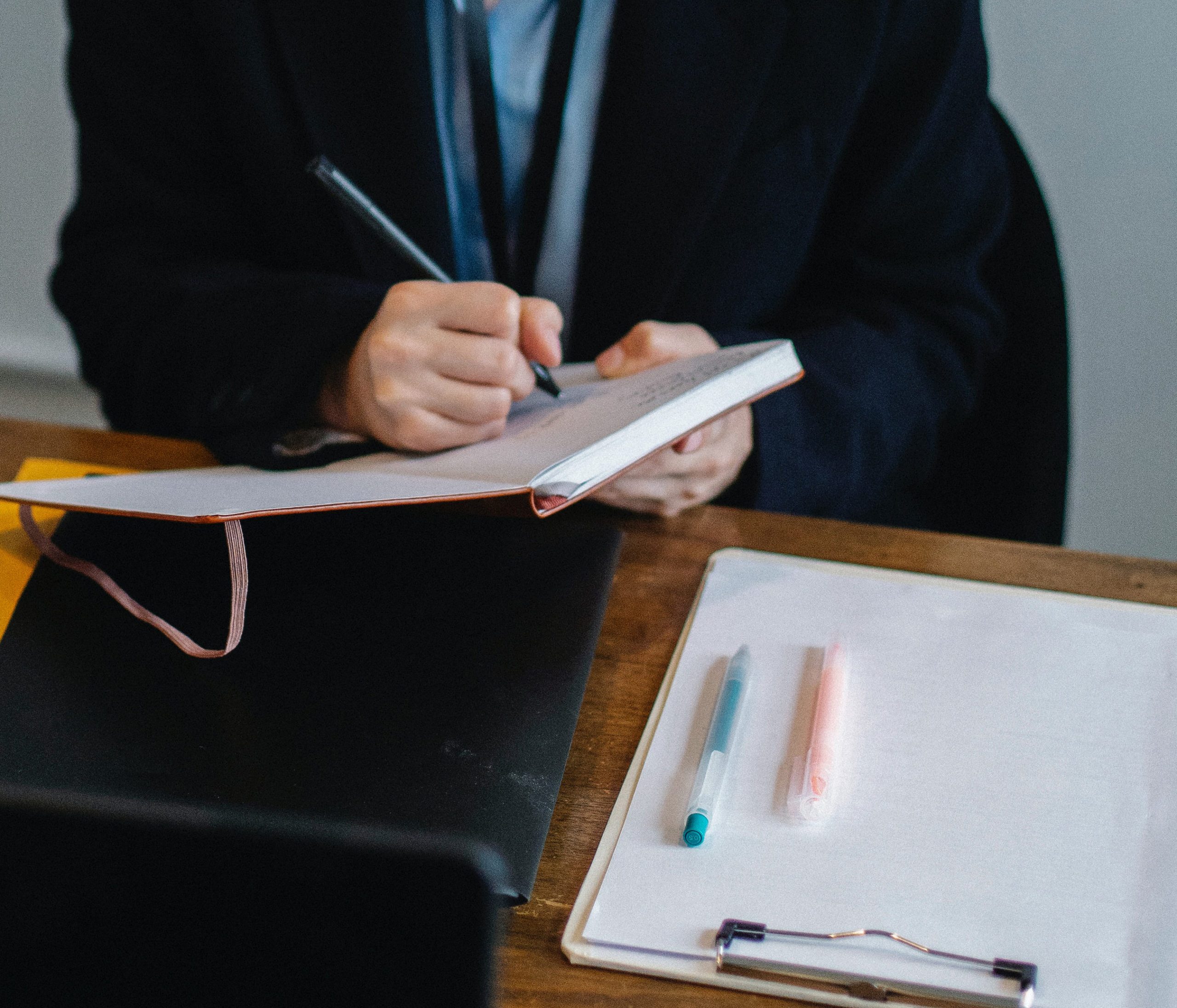 Professional woman writing on a notepad.