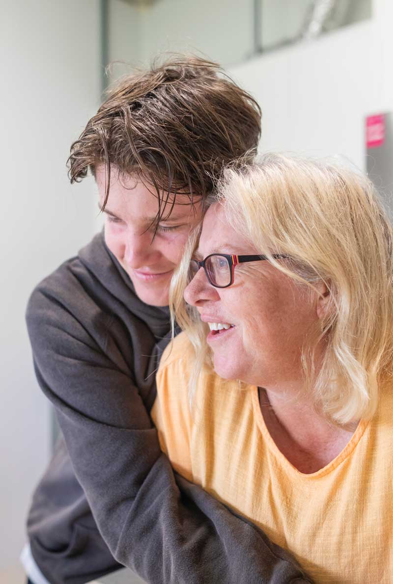 Mother and teenage son hugging